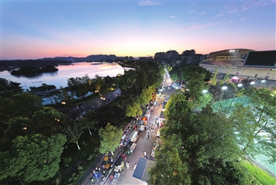 晚霞掩映下的双桂湖国家湿地公园夜市，灯火通明，热闹非凡。