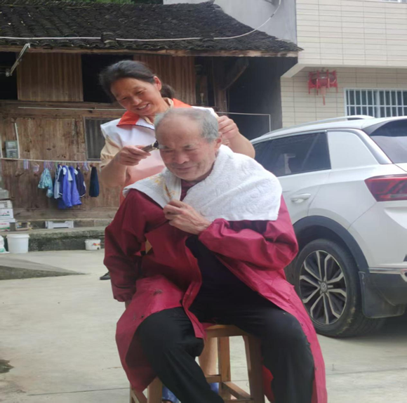 志愿者为老人理发。秀山县委宣传部供图